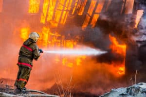 Fireman extinguishes a fire in an old wooden house